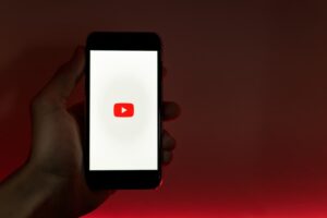 Handhaltendes Smartphone mit Internetzugang zu YouTube