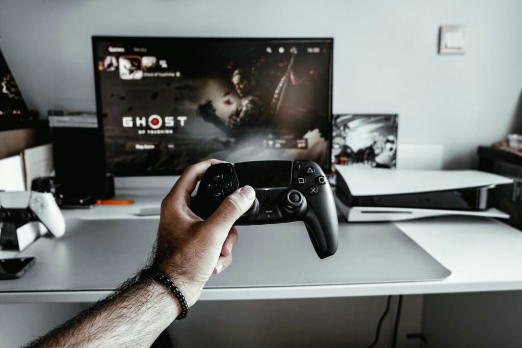Eine Person hält einen Videospiel-Controller vor einem Fernseher
