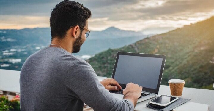 man on his laptop on a island