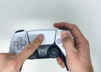 Person holding Sony PS5 DualSense Wireless Controller in both Hands and using White Touchpad on White Background