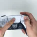 personne tenant la manette sans fil Sony PS5 Dualsense dans les deux mains et utilisant le pavé tactile blanc sur fond blanc
