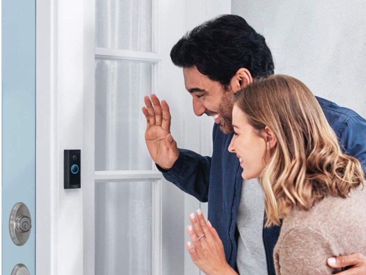 Two individuals greeting each other using a Ring Video Doorbell Wired.