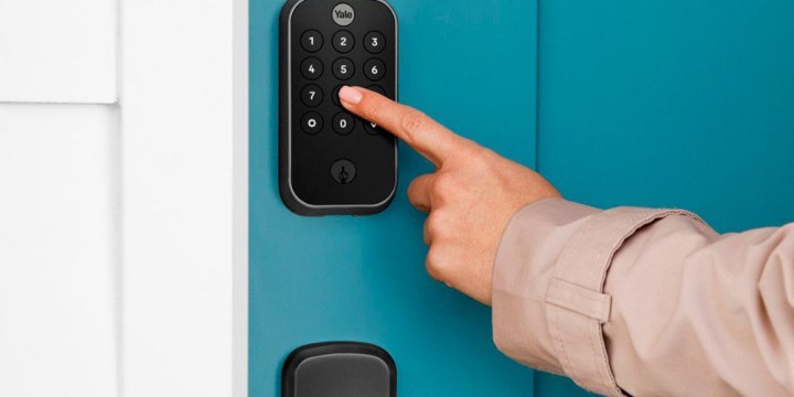 Someone using the Yale Assure Lock 2 Smart Lock Deadbolt keypad.