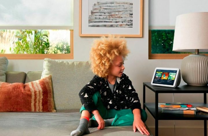 A child sitting on a couch observing the Amazon Echo Show (2nd Gen).