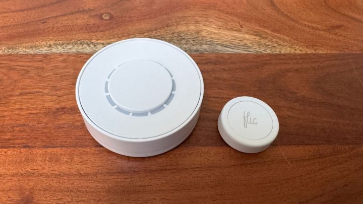 The Flic Twist and Smart Buttons displayed on a wooden tabletop.