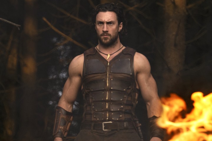 Aaron Taylor-Johnson stands near fire in Kraven the Hunter.