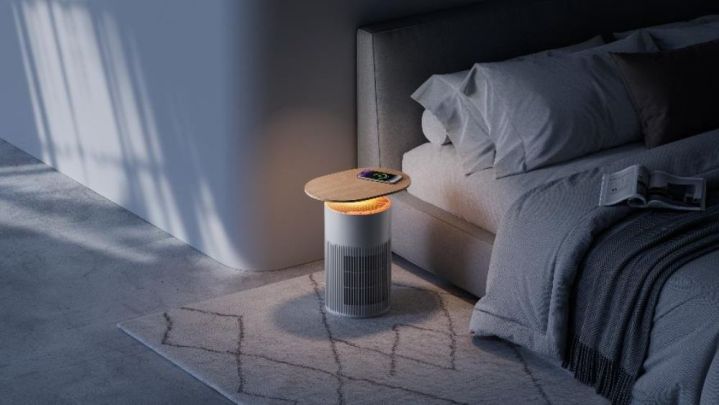 The SwitchBot Air Purifier Table positioned next to a bed.