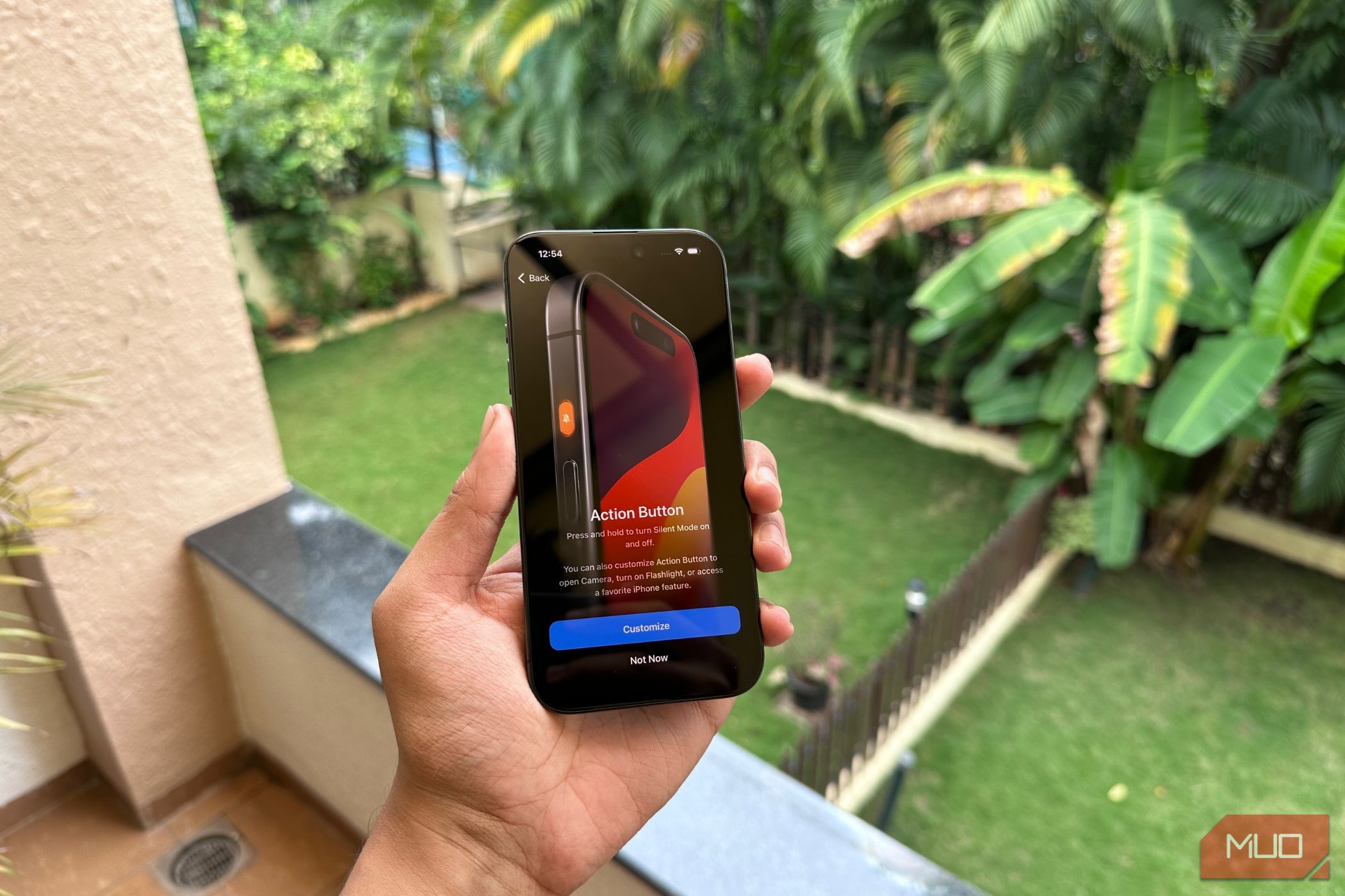 A man holding an iPhone 15 Pro showcasing the action button feature