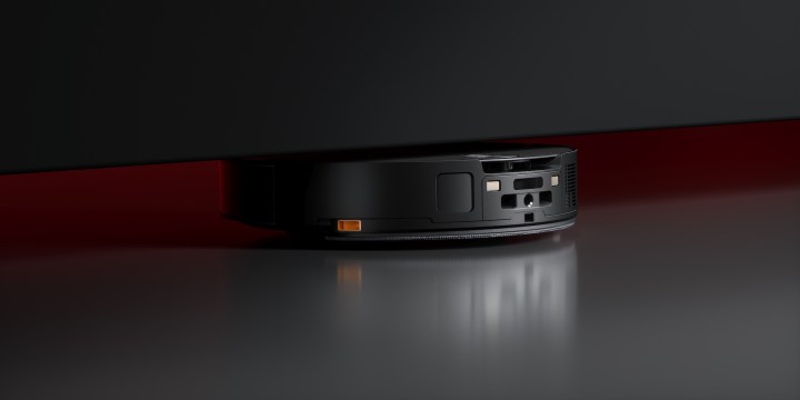 The Roborock Saros 10 navigating under a tight, low-clearance piece of furniture.