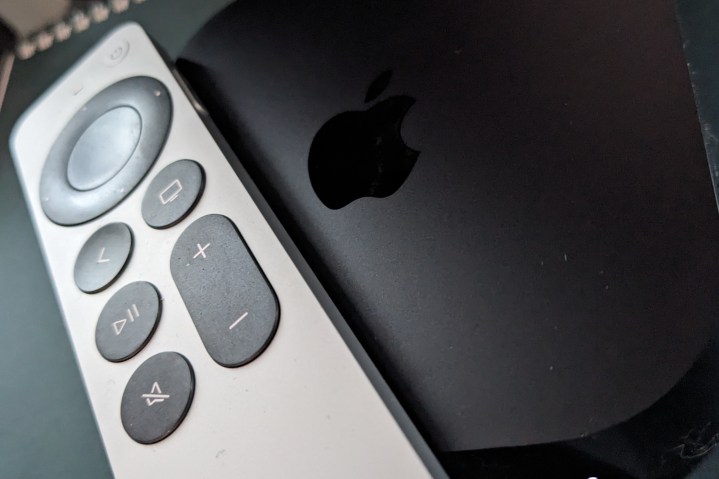 An Apple remote rests on top of an Apple TV 4K.