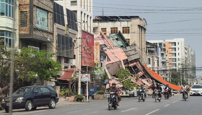Motorcyclists pass by a damaged structure after a strong earthquake hit Mandalay, Myanmar, on March 28, 2025. — Reuters