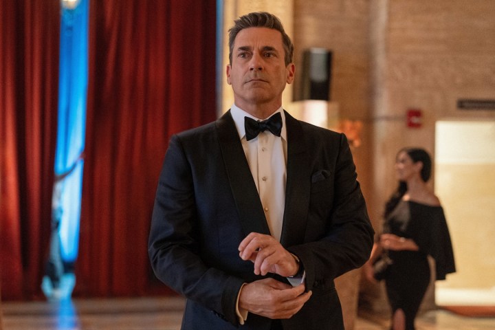 Jon Hamm adjusts his suit cuffs.