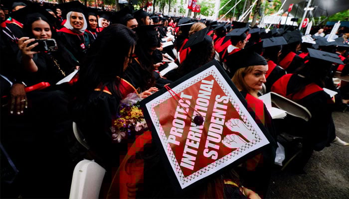 A student at a Harvard graduation event wearing a cap inscribed with a message in support of international students, May 29, 2025. — Reuters
