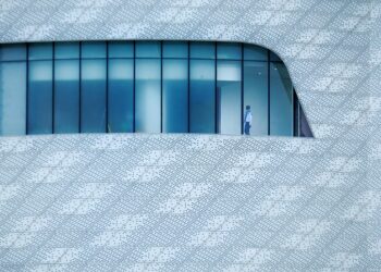 Three smartphones piled on a laptop keyboard