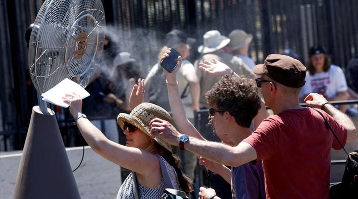 Tourists cool off with a fan outside the Colosseum amid the heatwave in Rome, Italy, June 30, 2025. — Reuters