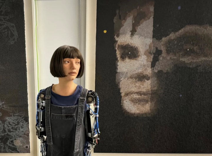 Ai-Da beside another of her artworks, this one of computer pioneer Alan Turing.