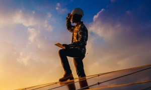 Promotion for Tech For Change. Person standing on solar panel at sunset.