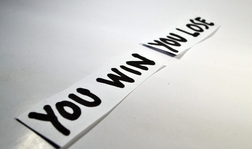 Tile sticky Bluetooth tracker held between fingers