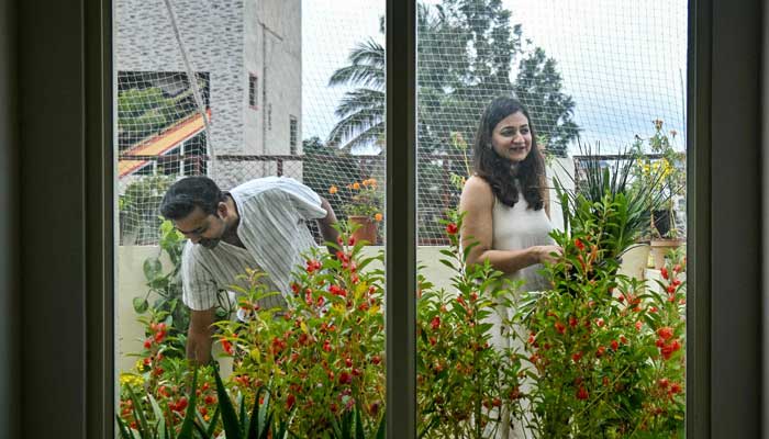Natasha Uppal (right), a pollution refugee and founder of maternal health support group Matrescence India, arranging plant pots with her husband Nikhil at their terrace garden in Bengaluru on September 27, 2025. — AFP