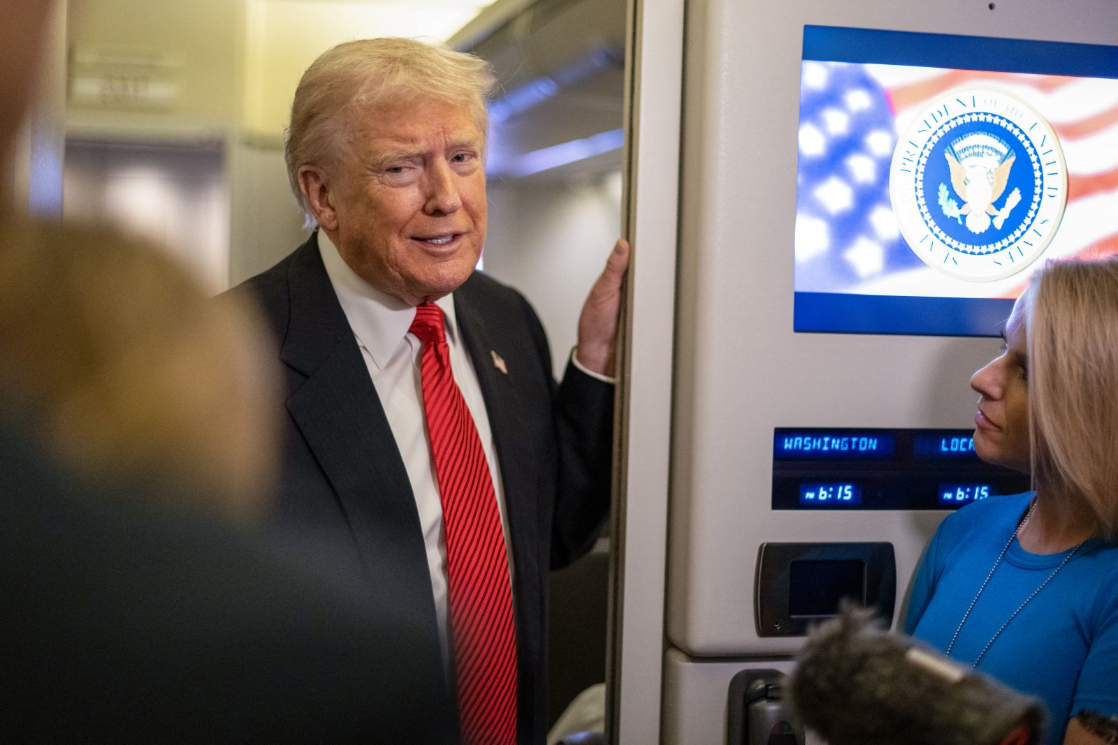 US President Donald Trump speaks to members of the press aboard Air Force