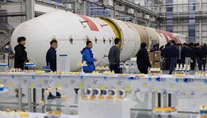 Employees gather around a test rocket for LandSpace’s Zhuque-2 project at its factory in Huzhou, Zhejiang province, China, December 17, 2025. — Reuters