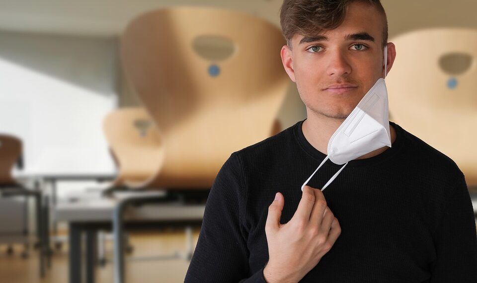 Finger pressing Windows key on a blue laptop keyboard