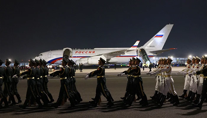 In this pool photograph distributed by the Russian state agency Sputnik, Chinese honor guards march past the aircraft carrying Vladimir Putin upon his arrival at Beijing Capital Airport late on May 19, 2026. — AFP
